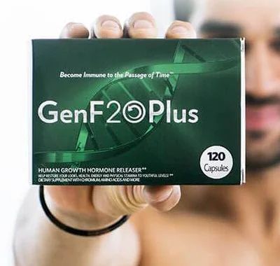 A hand holding the GenF20 Plus box up to the camera, its front label in focus and a person blurred behind