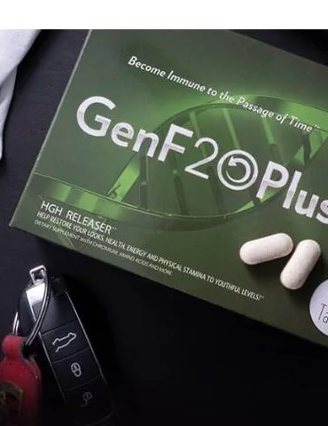 The GenF20 Plus box lying at an angle on a dark surface, two loose white tablets and a car key beside it